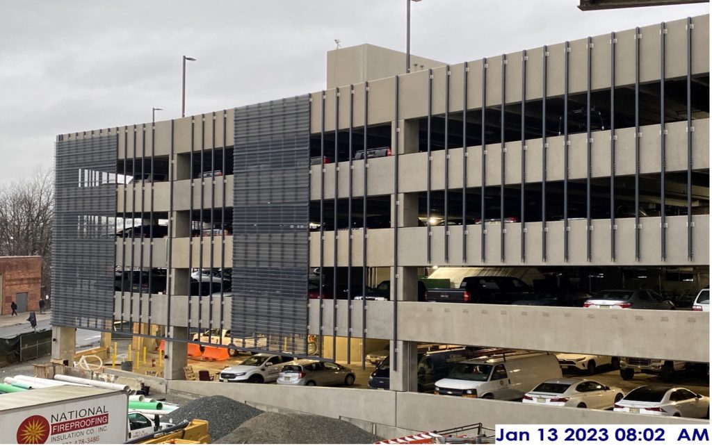 Installation of perforated metal screening façade at the parking garage.